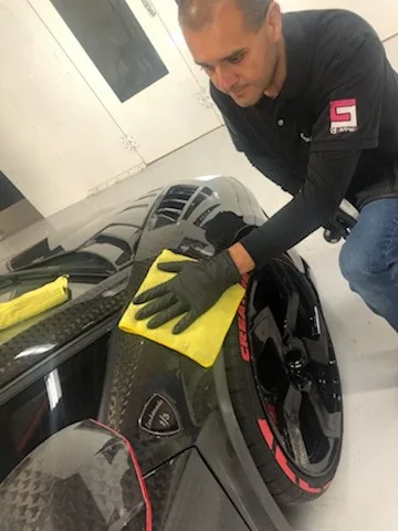 Technician hand-polishing a carbon fiber wheel