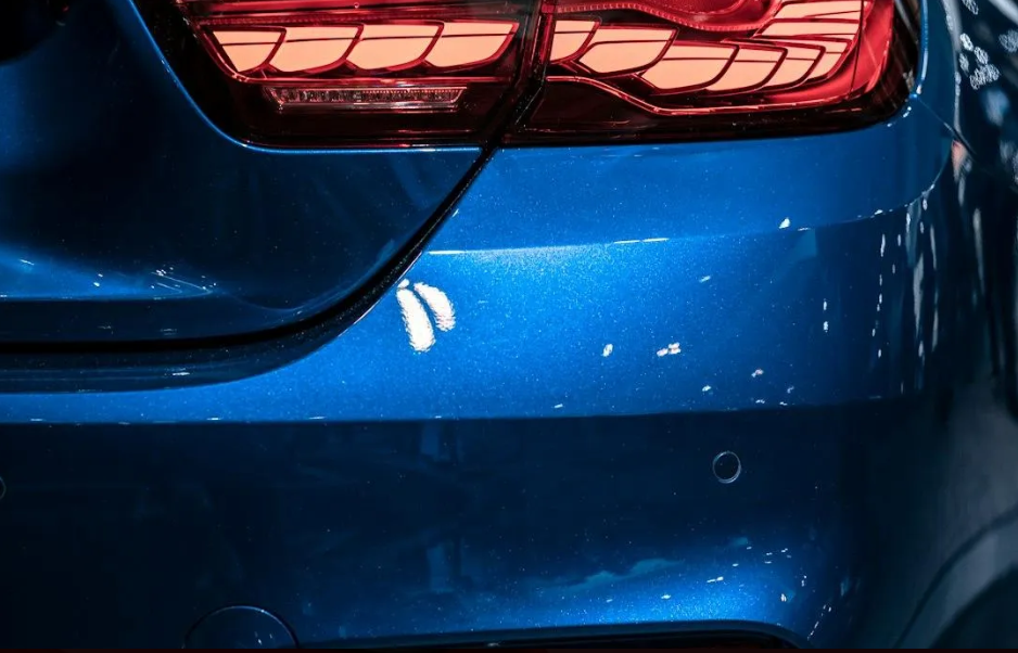 Close-up of a glossy blue vehicle rear showing scratch and abrasion resistant coating finish